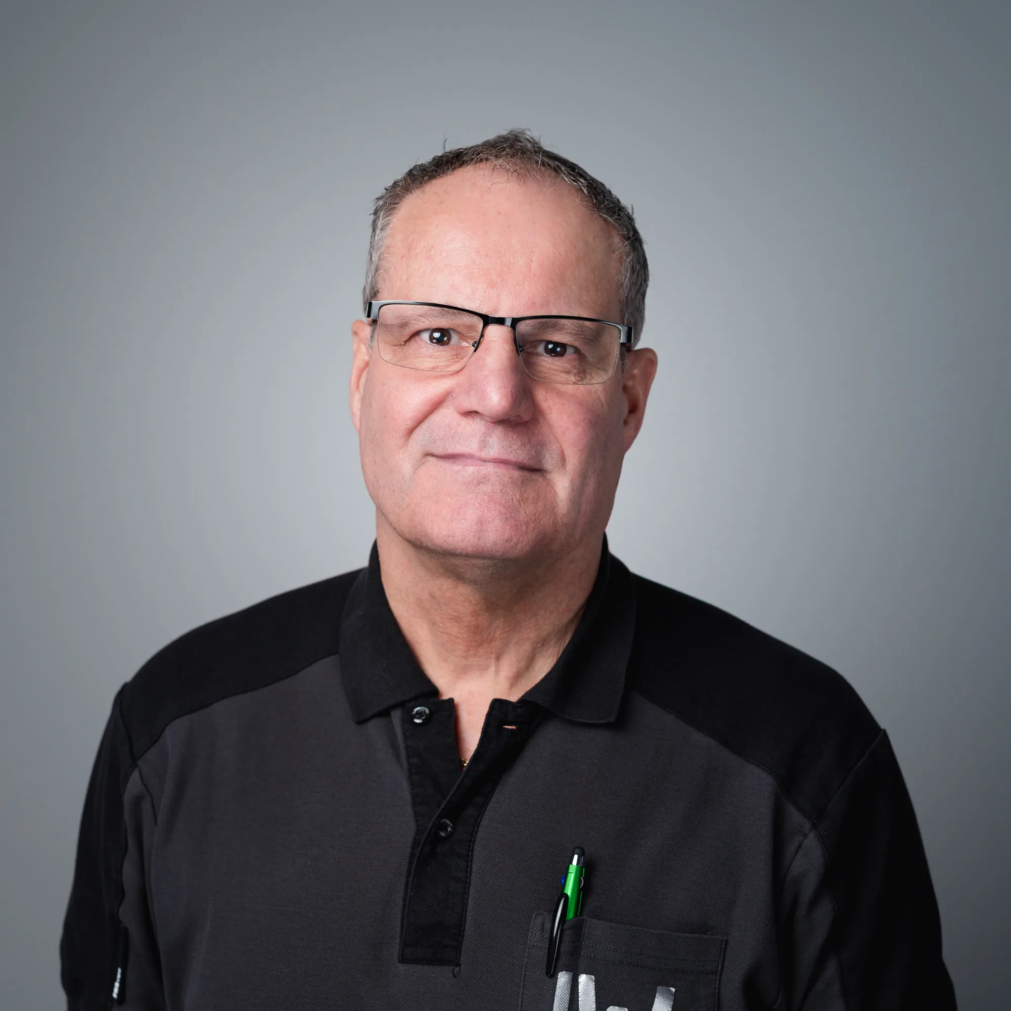 Porträt von Peter Rohlfing, einem Mann mittleren Alters mit Brille und dunklem Poloshirt, der freundlich in die Kamera blickt.