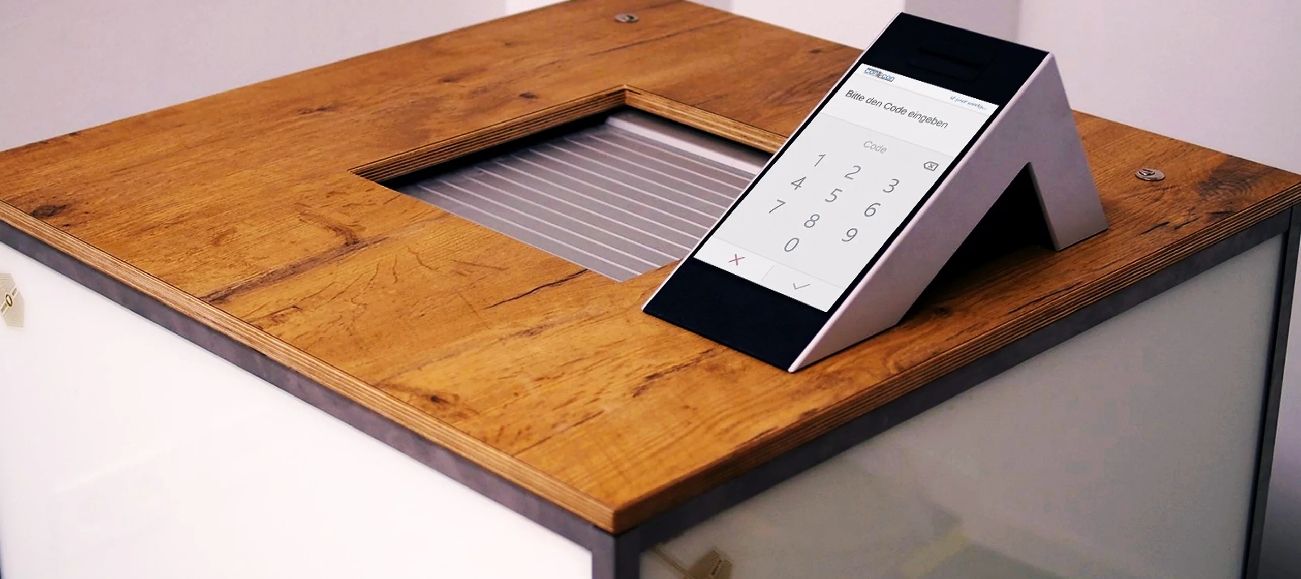Modernes Terminal mit Touchscreen zur PIN-Eingabe auf einem Schließfach-Modul aus Holz und Metall im Safe-Center Lübeck.