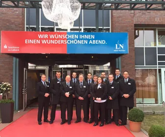 Veranstaltungsdienst des Lübecker Wachunternehmens: uniformiertes Sicherheitspersonal vor dem Eingang einer Abendveranstaltung.