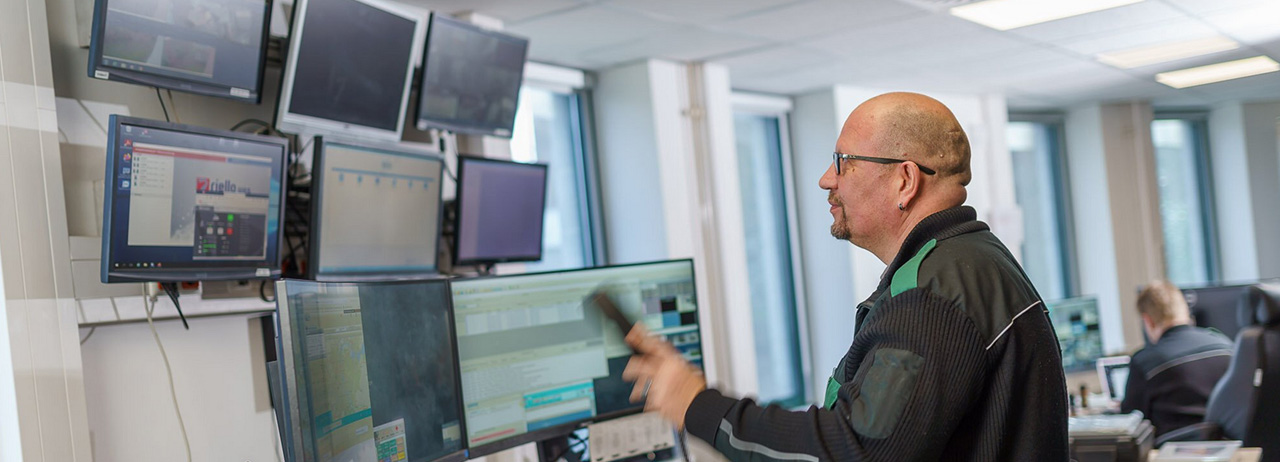 Mitarbeiter in der Sicherheitszentrale vor mehreren Monitoren.